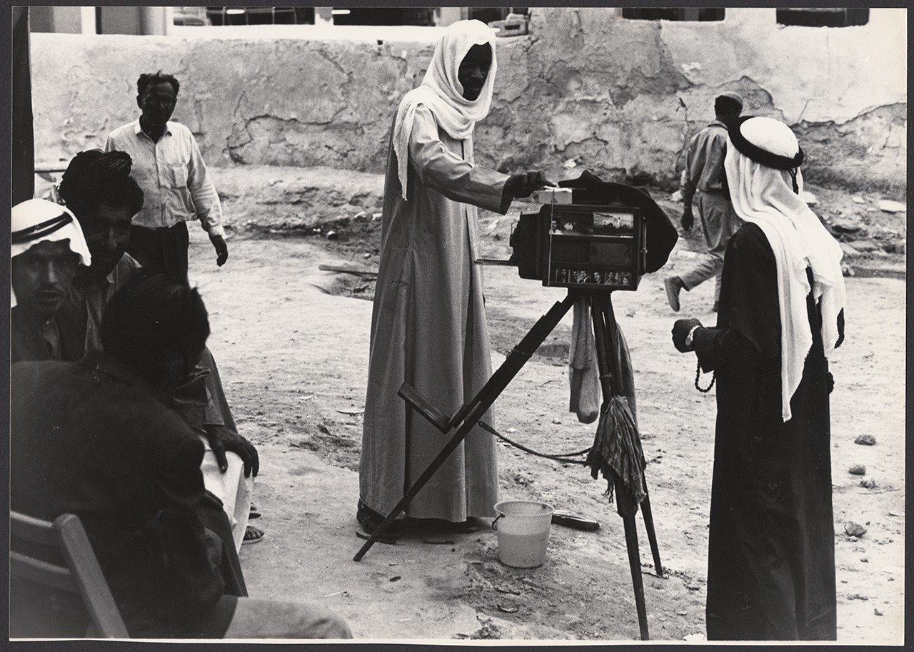 مصور شوارع بكاميرا تستخدم المعالجة الرطبة (أبوظبي، الإمارات العربية المتحدة، حوالي سبعينيات القرن العشرين)؛ مجموعة زكي نسيبة، أرشيف عكاسة للتصوير الفوتوغرافي. المرجع AD_MC_020_12