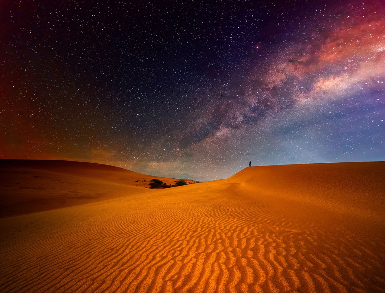 Stars light up the desert night sky.