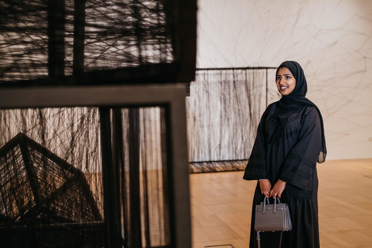 A woman observes a piece of art at the NYU Abu Dhabi Art Gallery.