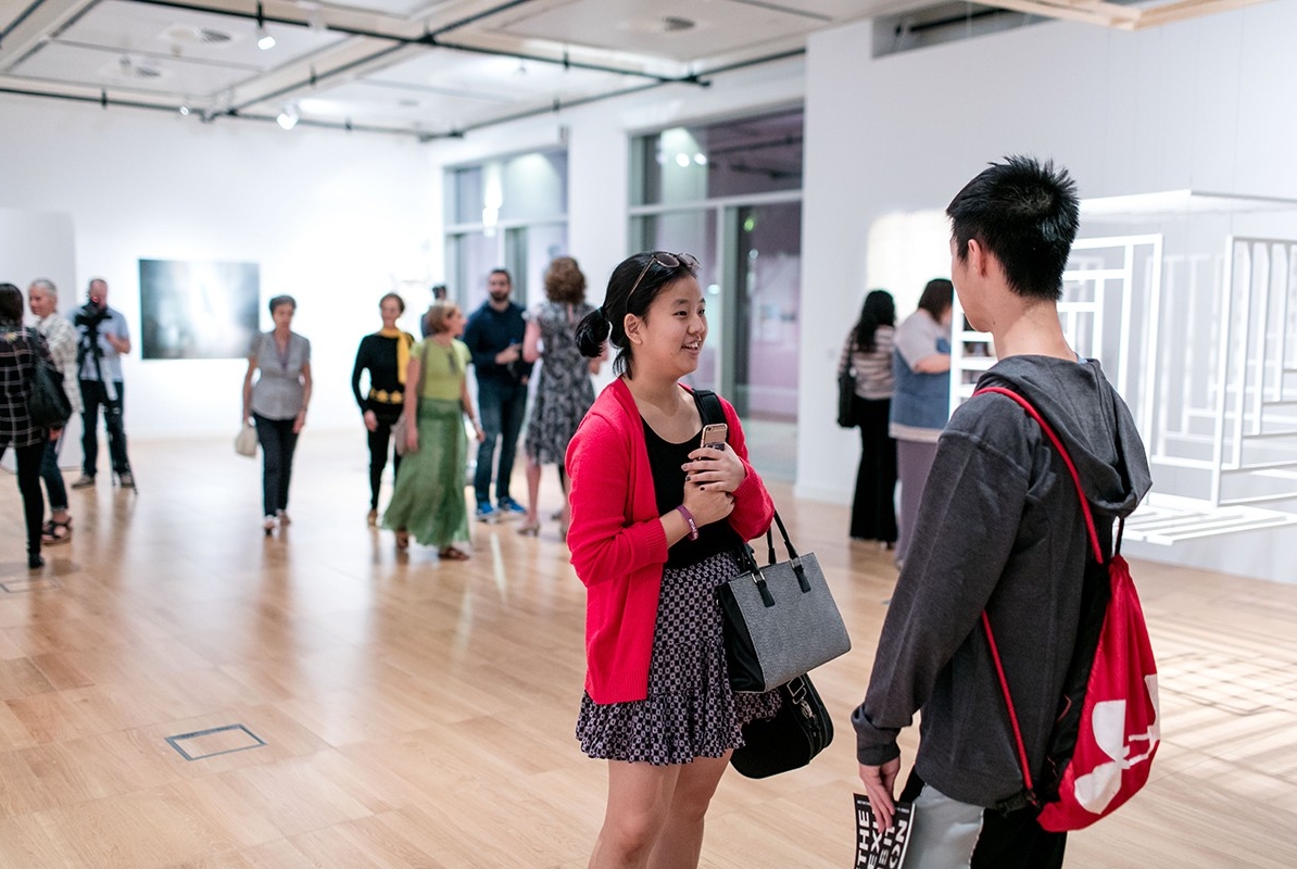 Students, faculty, and guests attend an opening of the NYU Abu Dhabi faculty art show at The Project Space in The Arts Center on the NYUAD campus.