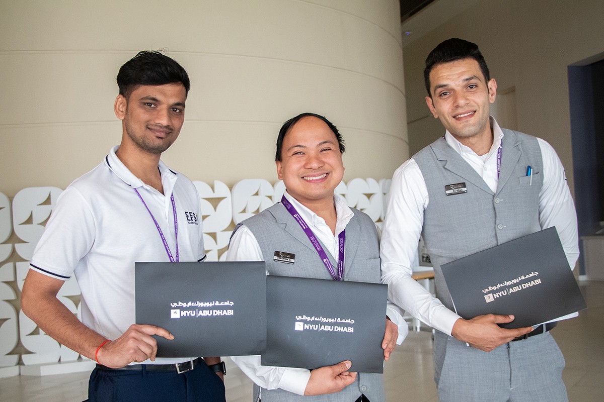  A trio of proud NYUAD contracted staff show off their newly earned adult education certificates.