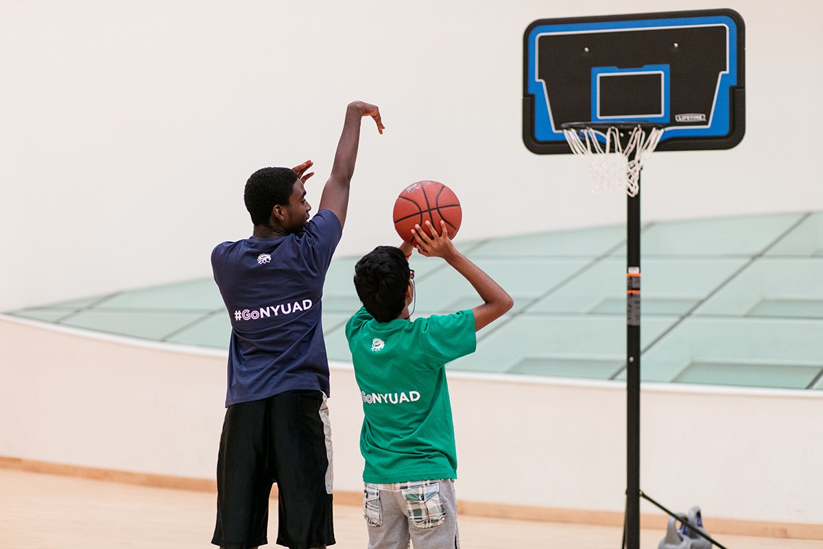 Student playing a game of basketball during a special needs volunteer program. 