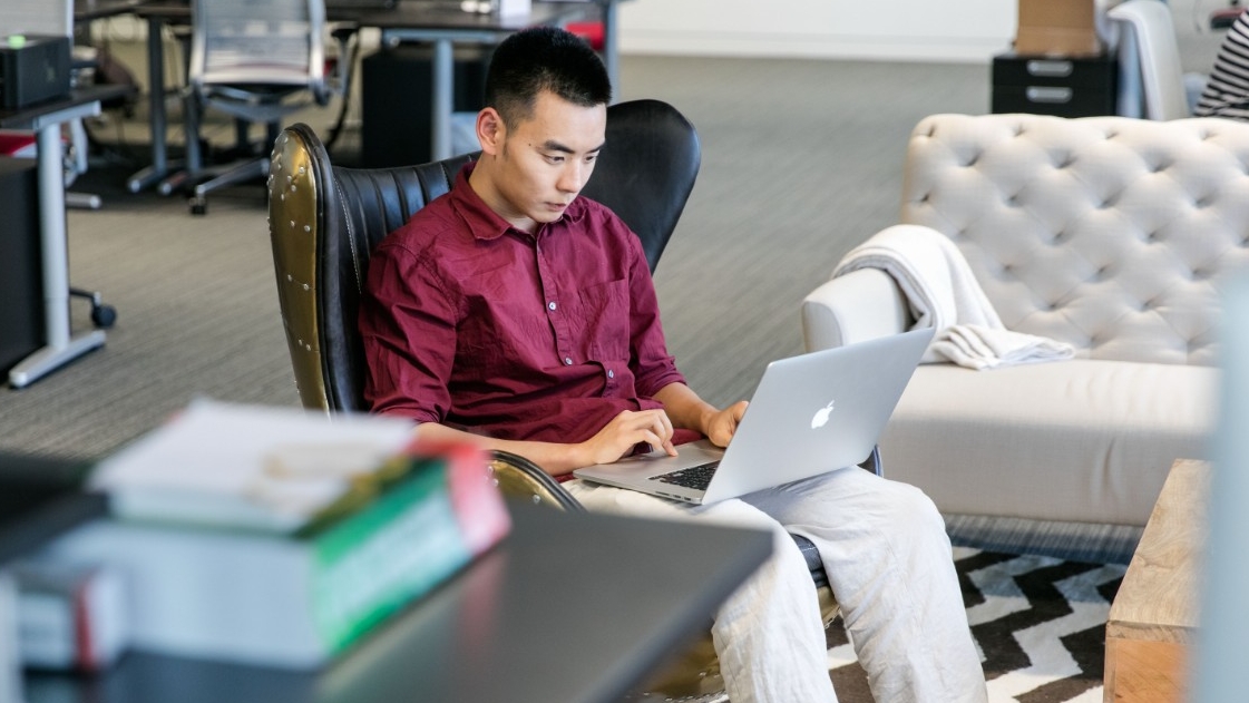 Ling Zhang, Class of 2016, works, writing code, during his internship at Palantir Technologies at the Capital Gate building in Abu Dhabi. 