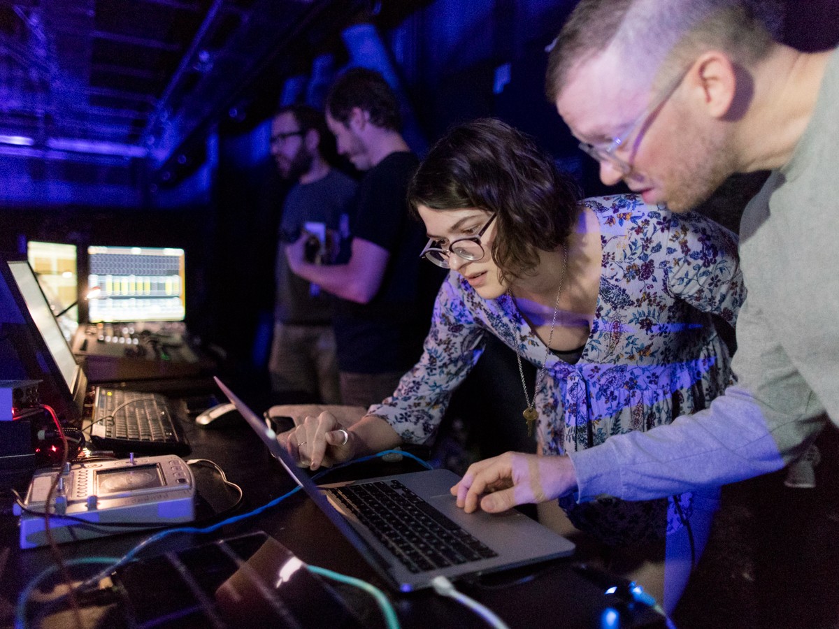 Professor Aaron Sherwood assists a student during a live performance of her project.