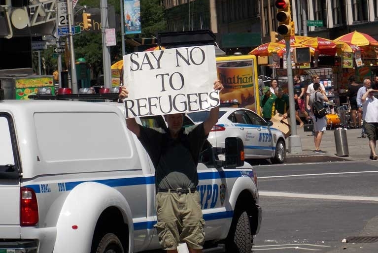 Man holds anti-refugee sign