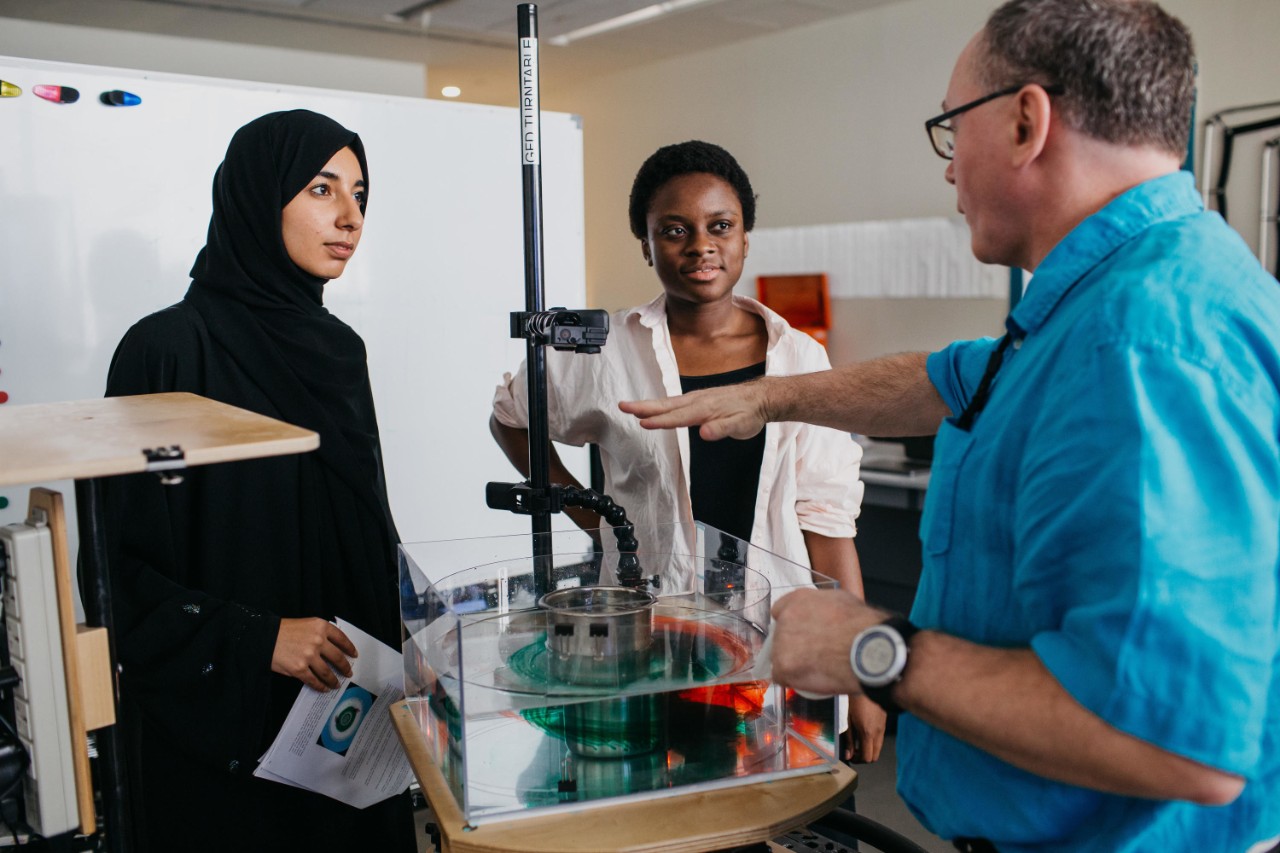 Professor David Holland speaks with undergraduate students at NYU Abu Dhabi.