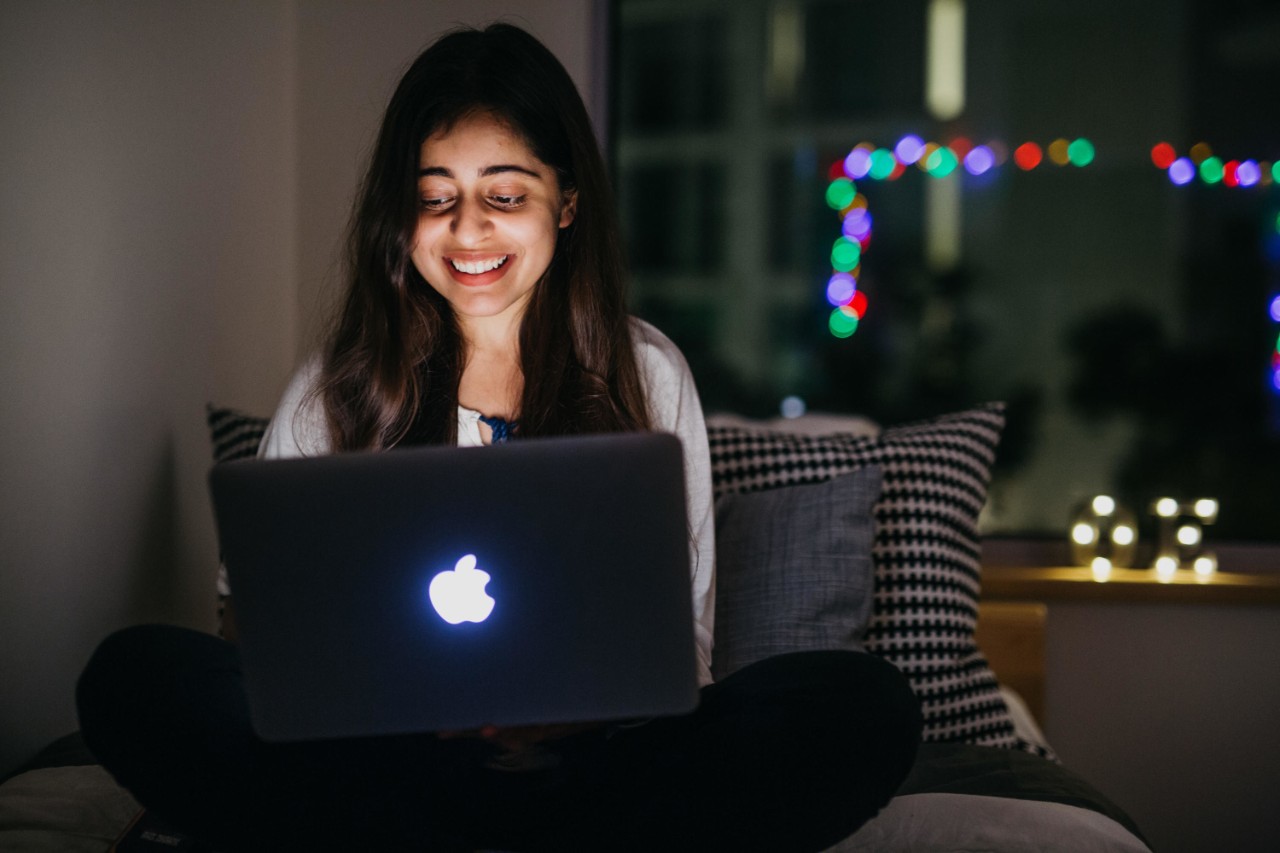 A happy student on her laptop at NYU Abu Dhabi.