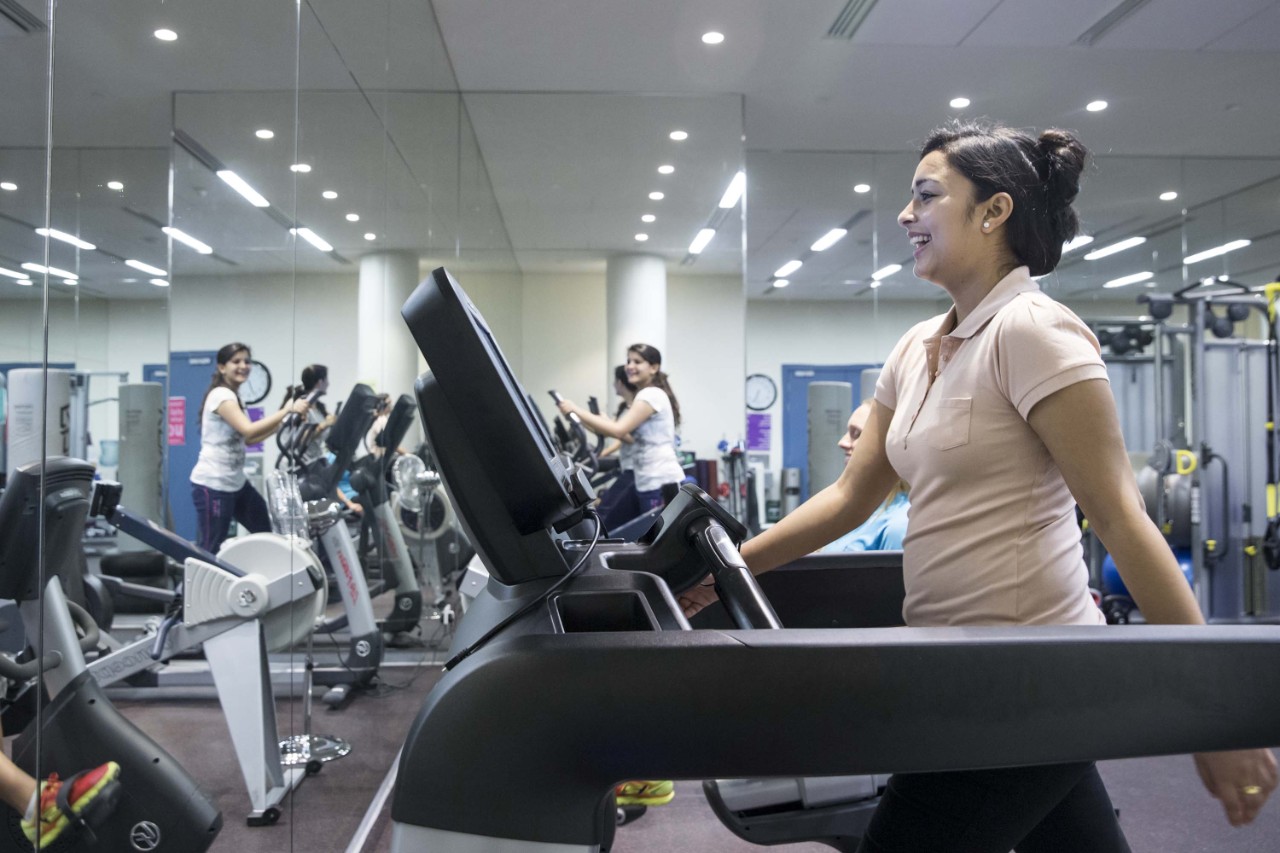 A female gym user using the treadmill in the ladies-only fitness room.
