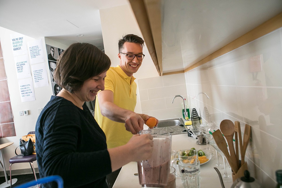 Seniors Yuliya Frolova and Dmitry Dobrovolskiy make smoothies in the dorm suite's common area.
