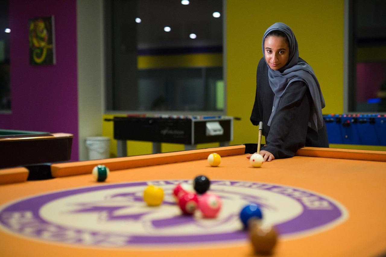 Student enjoying a game of pool in the Baraha area.