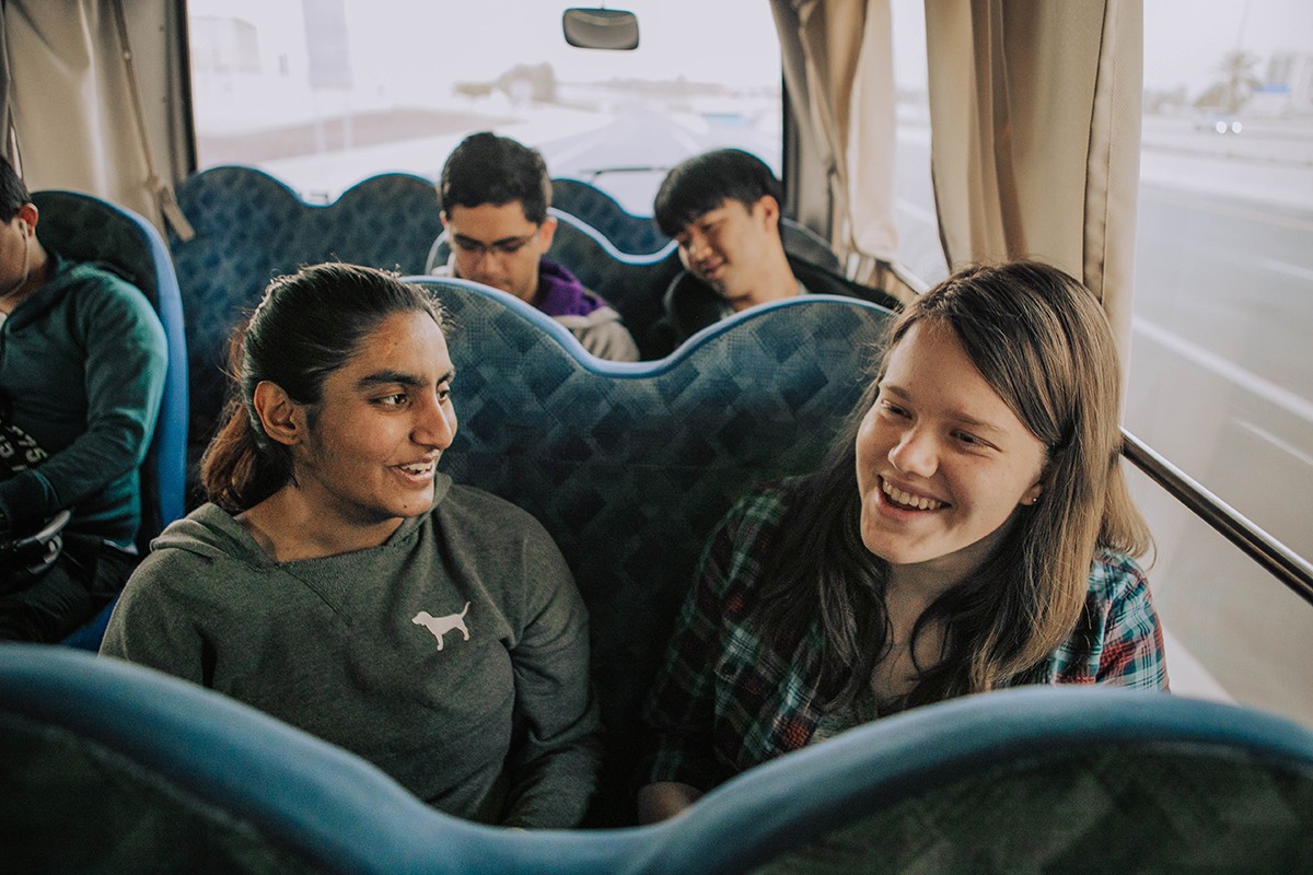 Mehak Sangani, left, and Katharina Klaunig, right, in a shuttle bus from NYU Abu Dhabi to downtown Abu Dhabi during their first year.  Photo taken pre COVID-19.