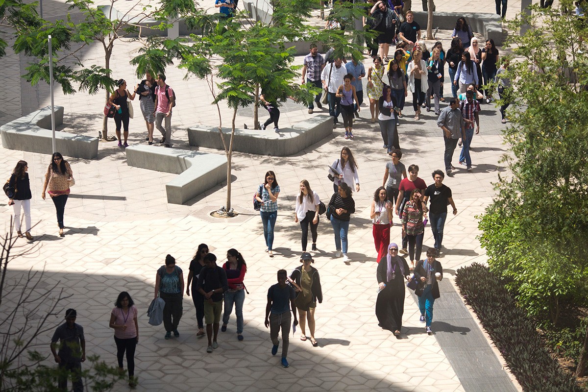 People walk through NYU Abu Dhabi's campus