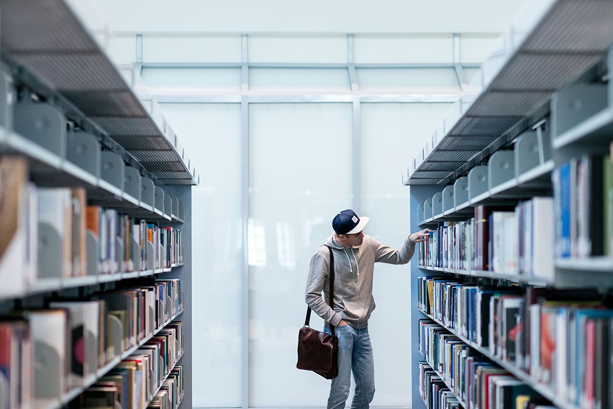 A student browses for books at the NYUAD Library.