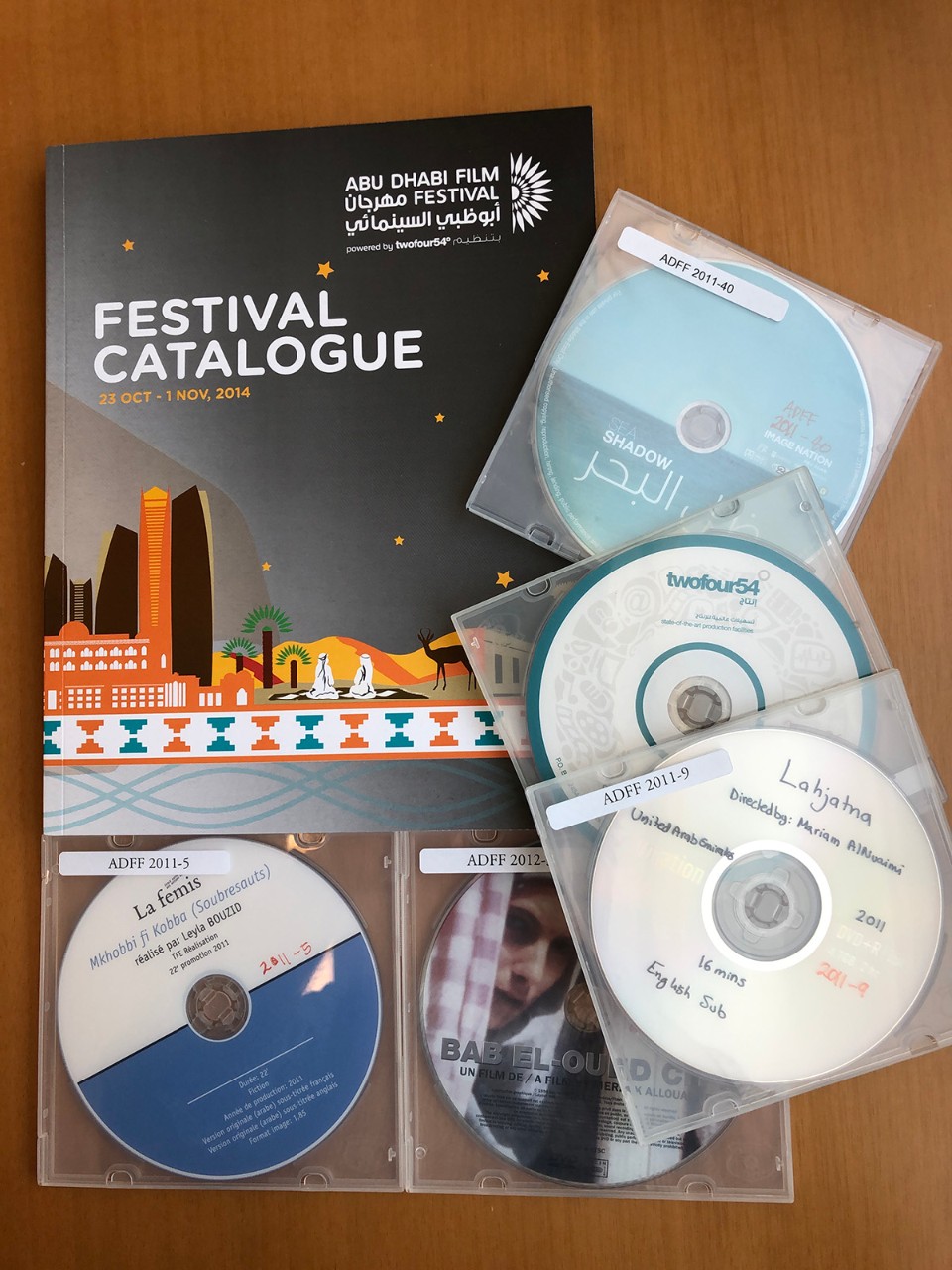 A sample of the Cimena and Filmmaking Collection from the NYU Abu Dhabi Library's Archives and Special Collections, featuring a film festival catalog and several DVDs.