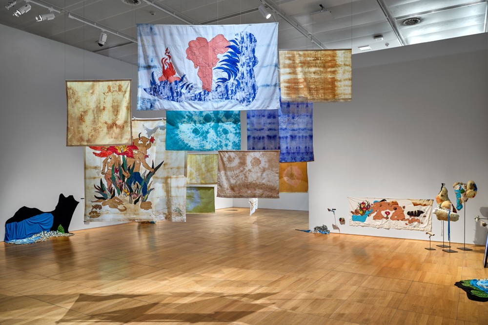 Installation view: Gözde İlkin, Entrusted Ground, 2022-ongoing. Dyed and stitched fabrics, fiber filling, stones, twigs, video, 3-channel sound, performance, dimensions variable. Photo: John Varghese