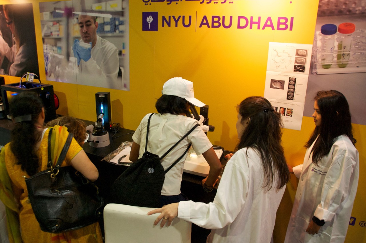 Students investigate microscopic samples at the NYUAD Think Science fair exhibit.
