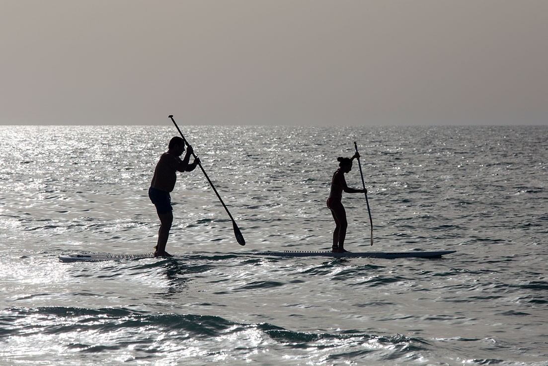 Two people on a stand up paddle board in Saadiyat Beach.