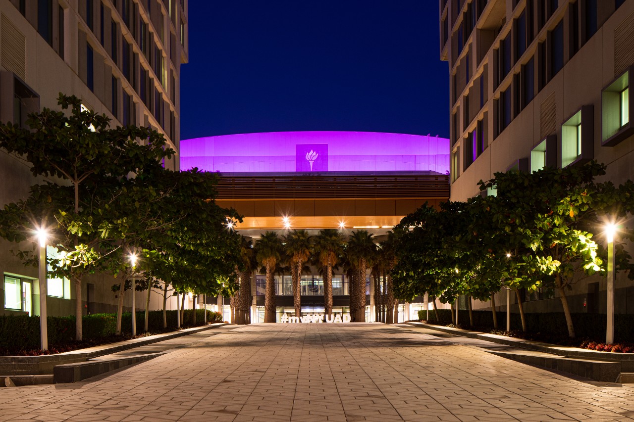 NYU Abu Dhabi's  campus dome lit up in violet in honor of the Class of 2020