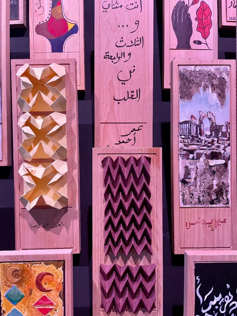 Diverse wooden slabs painted by Syrians who had left home being shown in the Syrian Pavilion at Expo 2020.