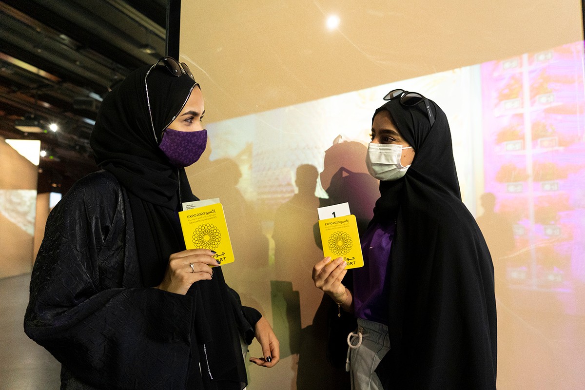 Students holding on to the yellow passports of Expo 2020. 