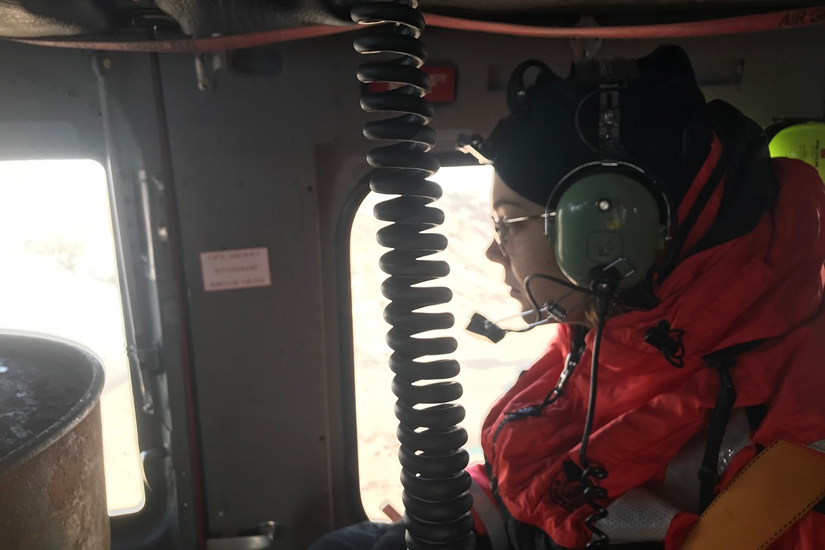 August 5, 2019, NYU graduate student Aurora Basinski-Ferris prepares to deploy a temperature probe from a hovering helicopter into a melt-plume at the calving front of the Helheim Glacier. It was discovered that the water temperature was far above freezing from top to bottom. The presence of such warm water abutting to a calving front surprised researchers.