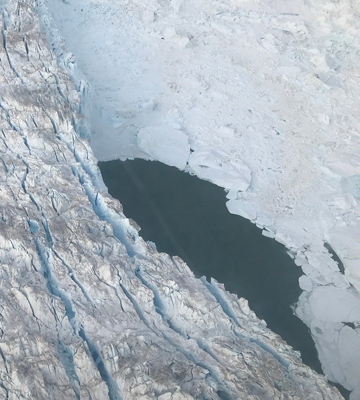 August 5th, 2019.  Researchers from NYU New York and Abu Dhabi identify an unexpected and large opening in the melange at the calving front of the Helheim Glacier. A temperature probe was deployed and results showed a uniform temperature of approximately 4 degree centigrade from top to bottom. Image credit: Denise Holland, NYU Abu Dhabi Center for Global Sea Level Change.