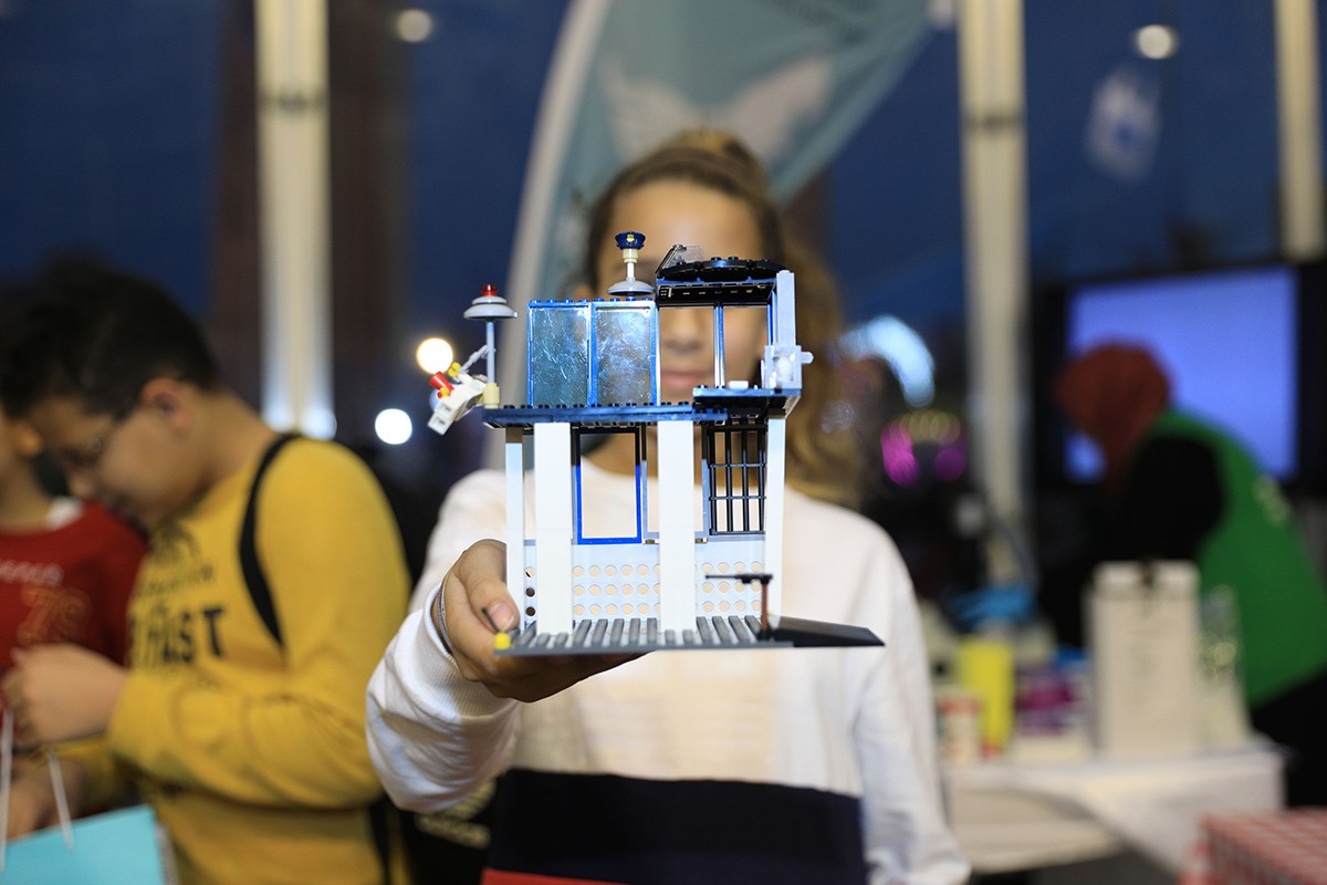 A young participant presents her civil engineering lego replica at the Abu Dhabi Science Festival.