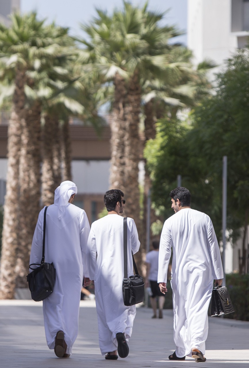 Three Emirati students walking toward Campus Center