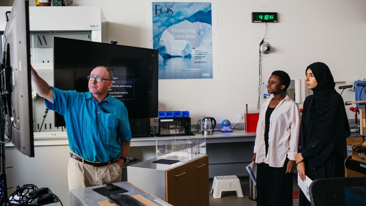 Math professor David Holland instructs two students in the Center for Sea Level Change at NYU Abu Dhabi.